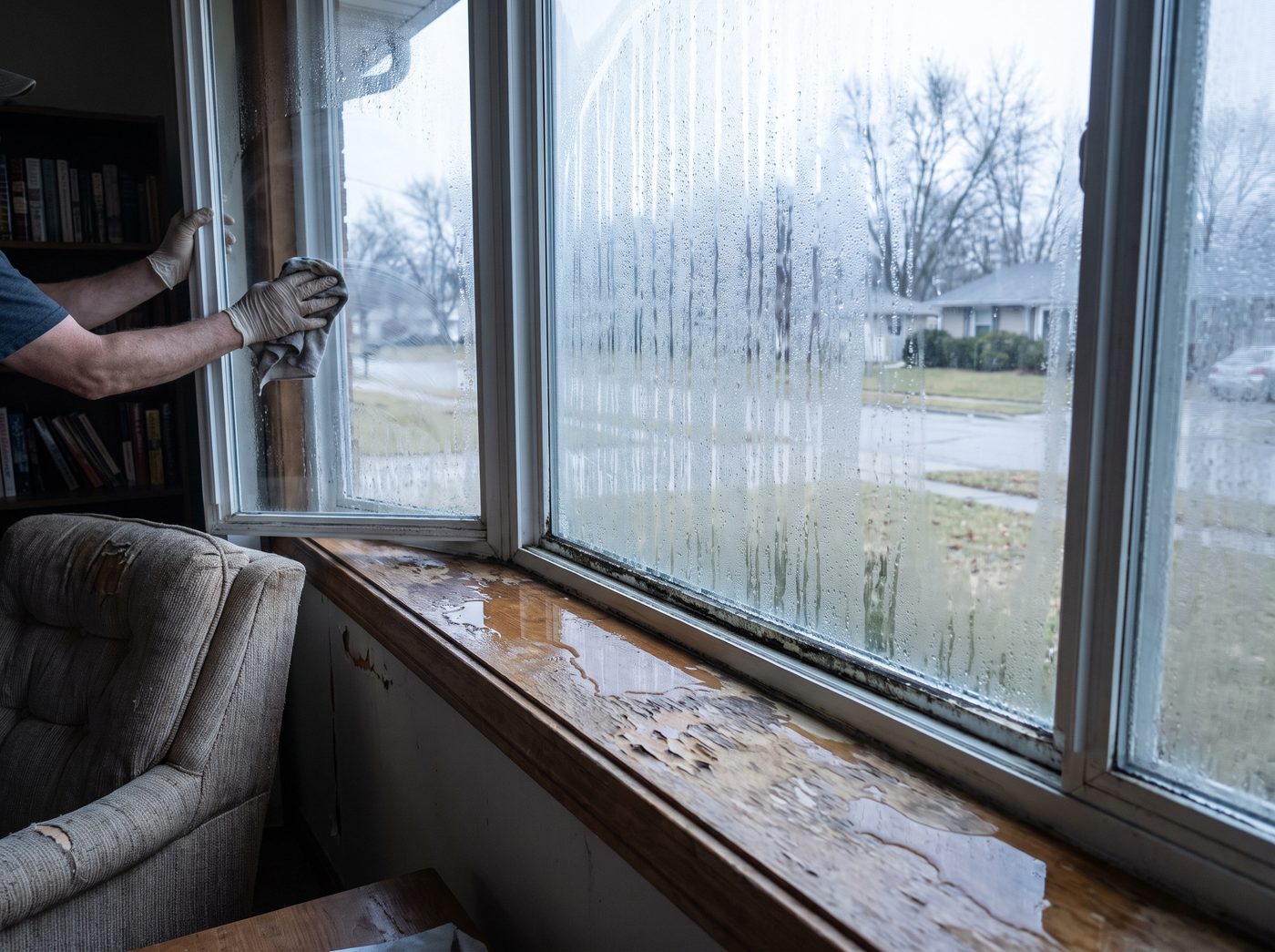 Heavy condensation running down the inside of a window with water pooling on the sill